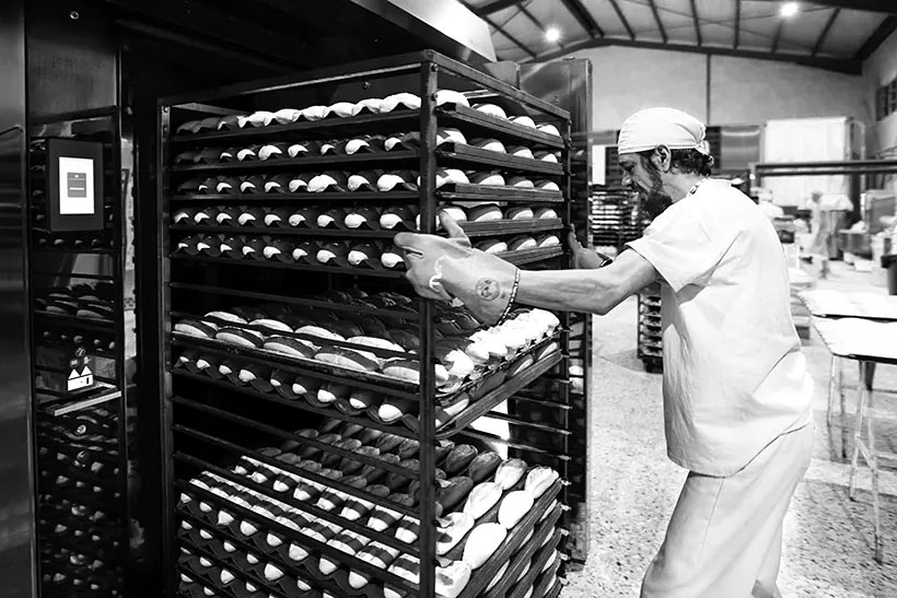Operario introduciendo pan en el horno